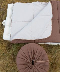 Sac de couchage en laine naturelle déplié à l’extérieur, offrant une isolation optimale contre le froid et l’humidité.