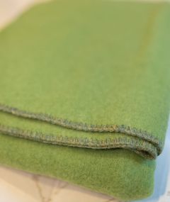 Plaid vert tilleul plié et facilement rangé, pratique pour un usage quotidien tout en restant élégant.