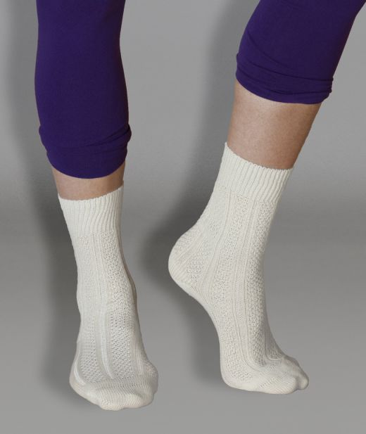 Chaussettes fantaisie en laine mérinos et coton biologique, montrées en studio sur fond neutre, mettant en avant leur design raffiné et leur maille en relief délicate.