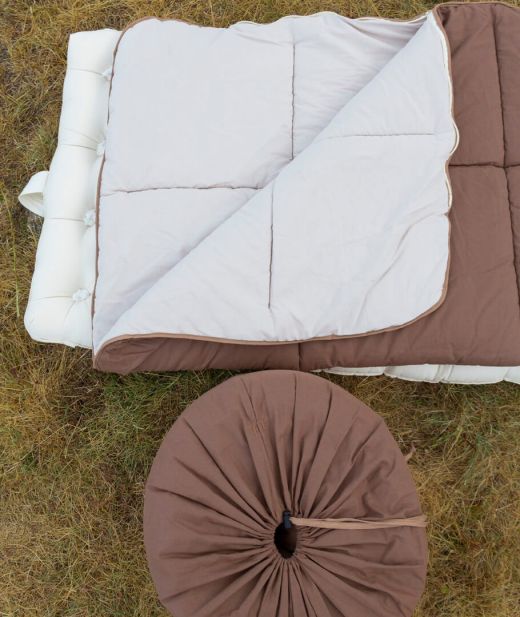 Sac de couchage en laine naturelle déplié à l’extérieur, offrant une isolation optimale contre le froid et l’humidité.