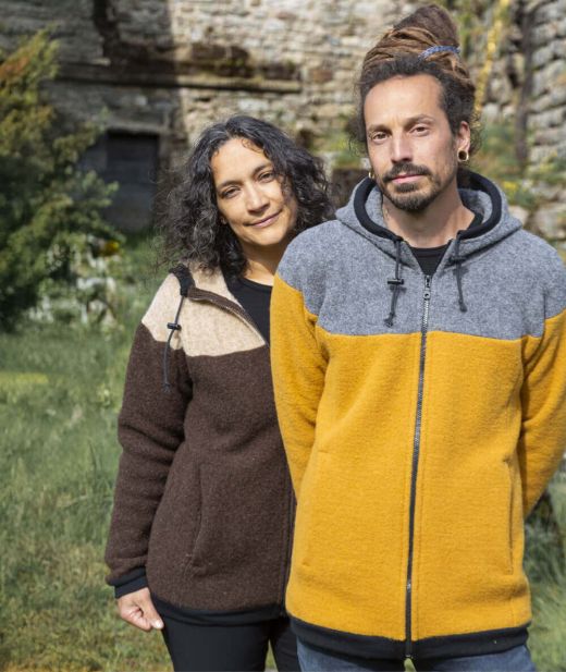 Couple portant les vestes en laine mixte, homme en jaune/granit et femme en burel/bizet, style hiver chaud et naturel, fabrication artisanale française