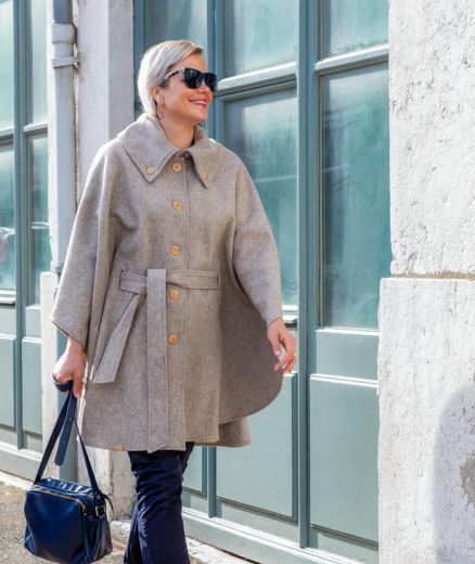 Cape beige en laine recyclée pour femme, offrant chaleur et confort avec une coupe moderne et élégante.
