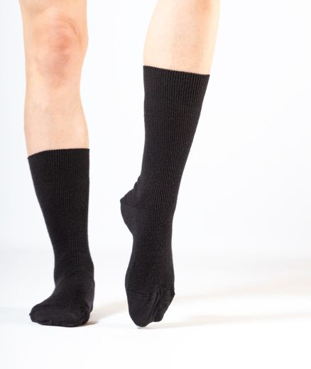 Chaussettes noires fines en pure laine mérinos, photographiées en studio avec un éclairage mettant en valeur leur légèreté et la qualité du tricot.