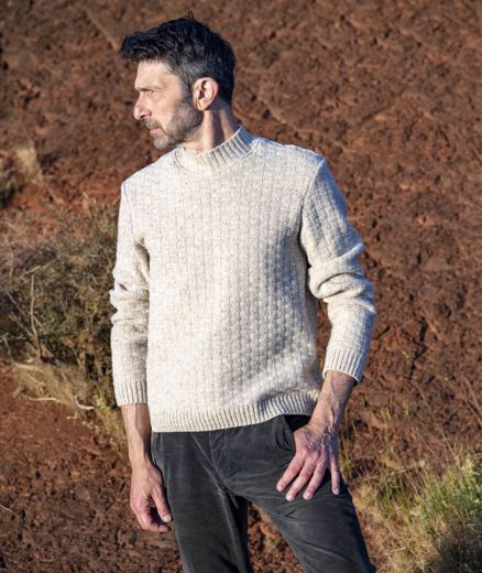 Portrait de face d’un homme portant un pull en laine Kasha à col rond et motif tressé