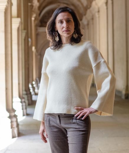 Femme portant un pull en laine mérinos couleur écru, style sobre, élégant et confortable.