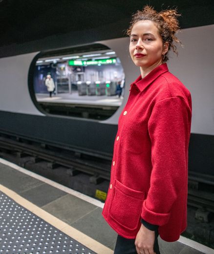 Vue de profil gauche de la veste rouge en laine recyclée, coupe ample et élégante.